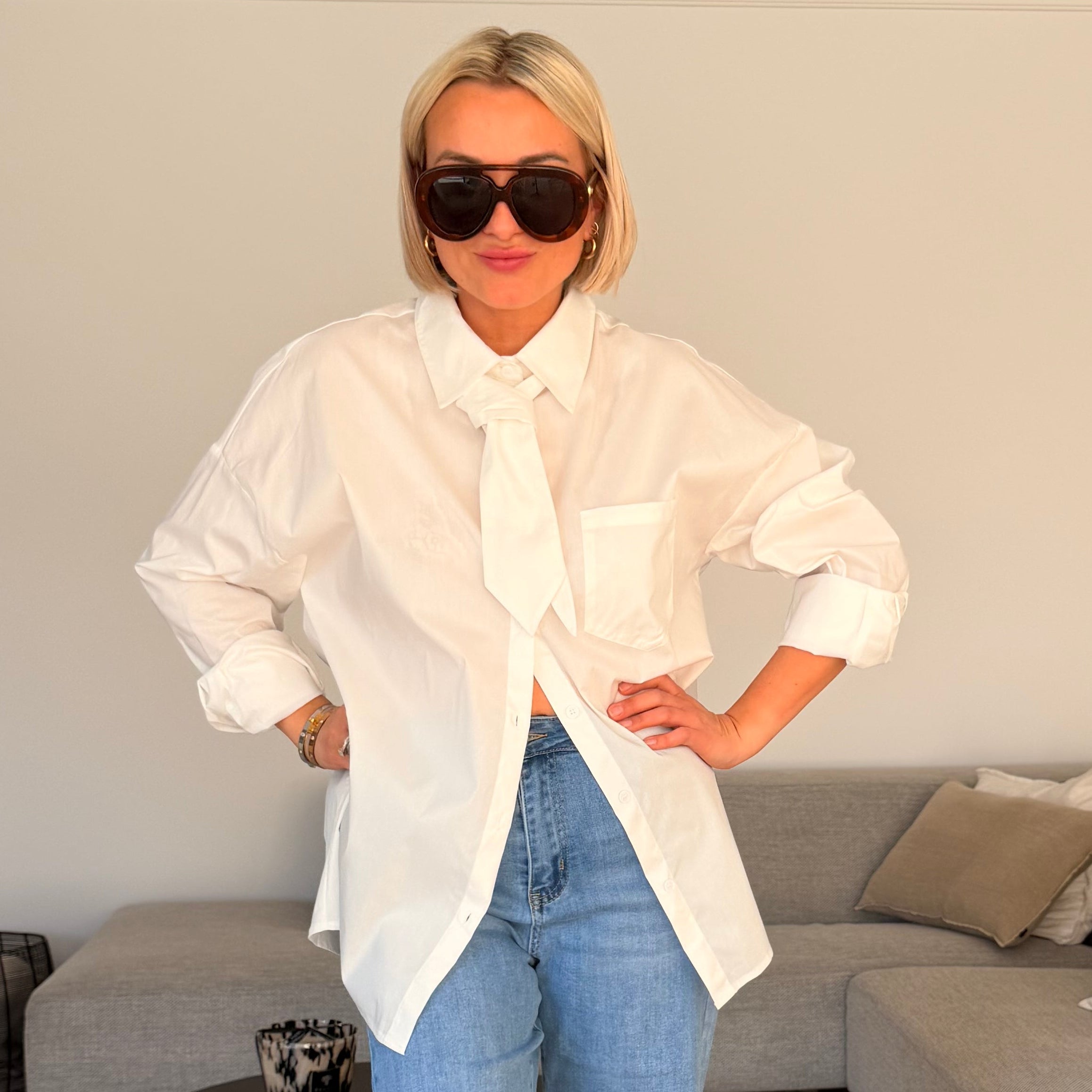 Chemise blanche oversize avec lien à nouer façon cravate. Chic, moderne et parfaite pour un look élégant et tendance.