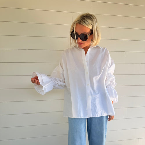 Chemise blanche oversize à manches volumineuses portée avec jean large – look chic minimaliste femme