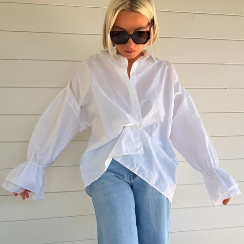 Chemise blanche oversize à manches volumineuses portée avec jean large – look chic minimaliste femme