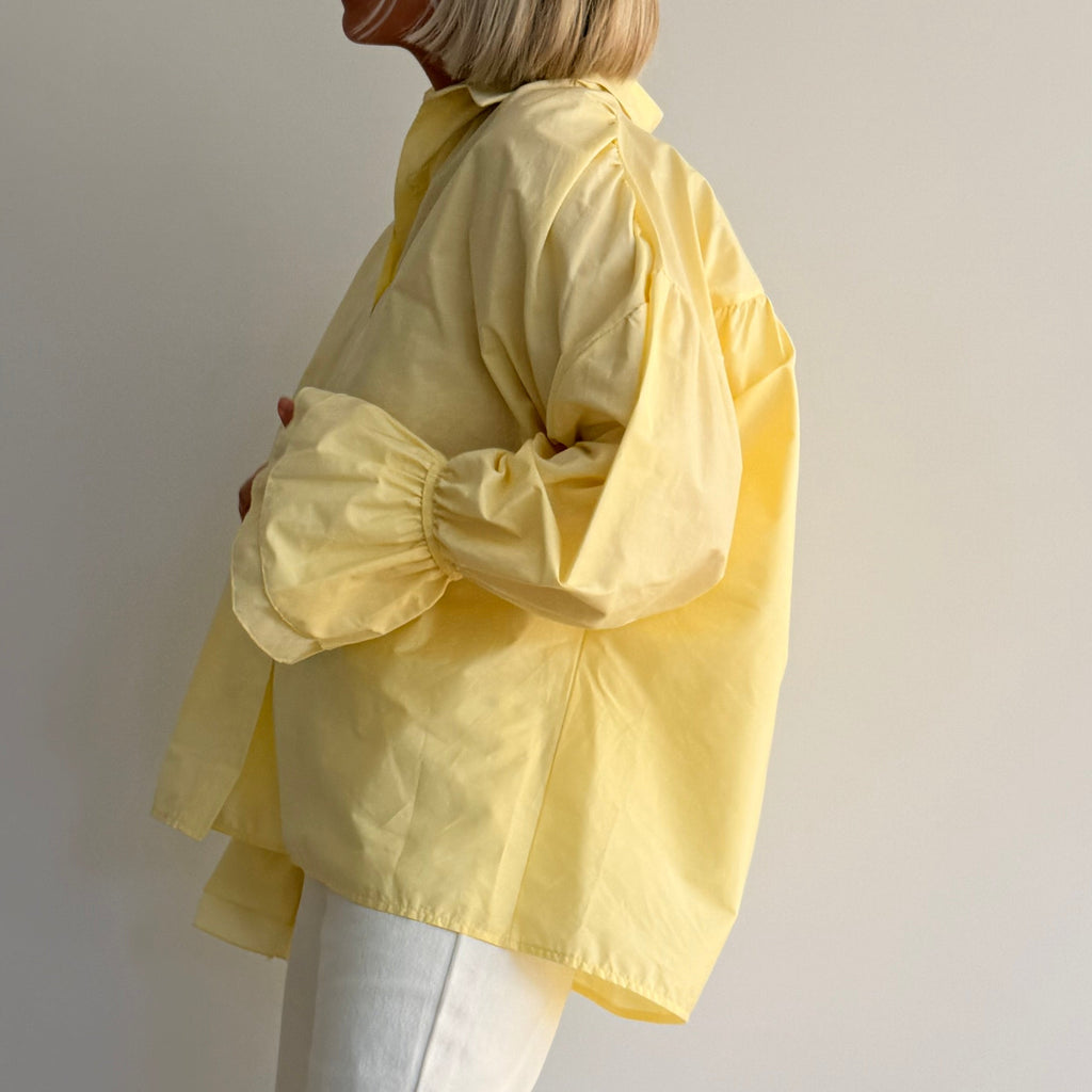 Chemise jaune pastel oversize à manches volumineuses portée avec jean large – look chic minimaliste femme