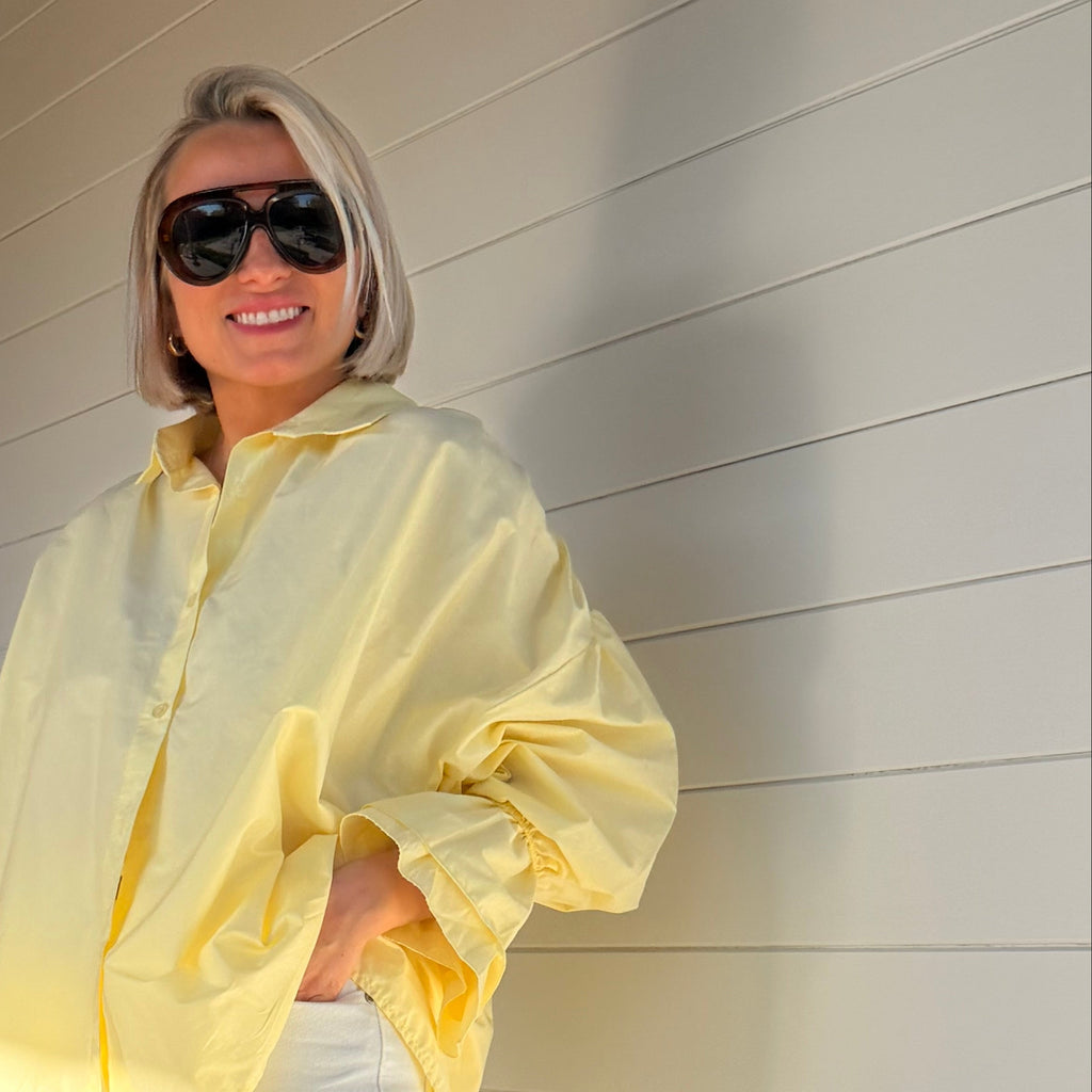 Chemise jaune pastel oversize à manches volumineuses portée avec jean large – look chic minimaliste femme