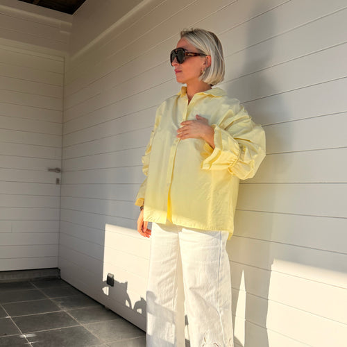 Chemise jaune pastel oversize à manches volumineuses portée avec jean large – look chic minimaliste femme