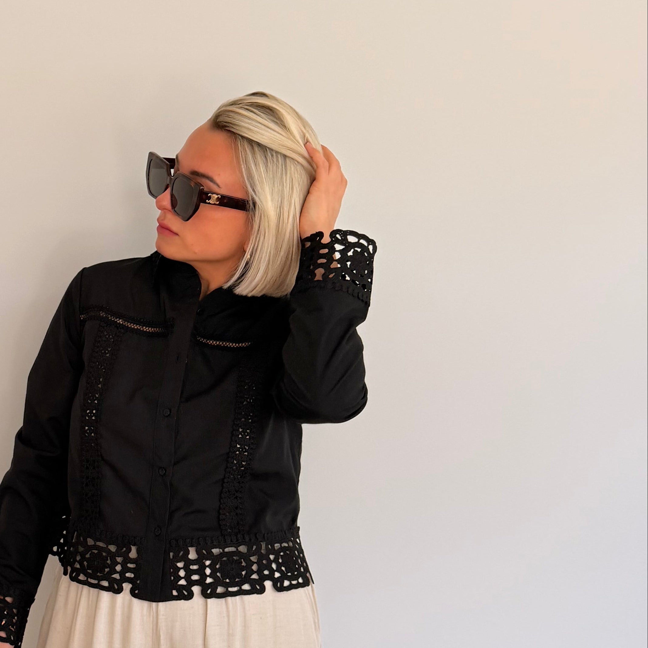 Chemisier noir avec détails ajourés et finitions dentelle. Élégant, féminin et parfait pour un look chic.