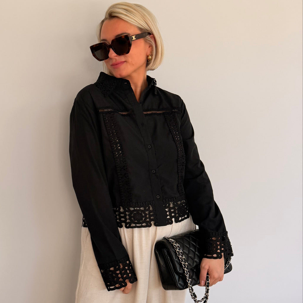 Chemisier noir avec détails ajourés et finitions dentelle. Élégant, féminin et parfait pour un look chic.