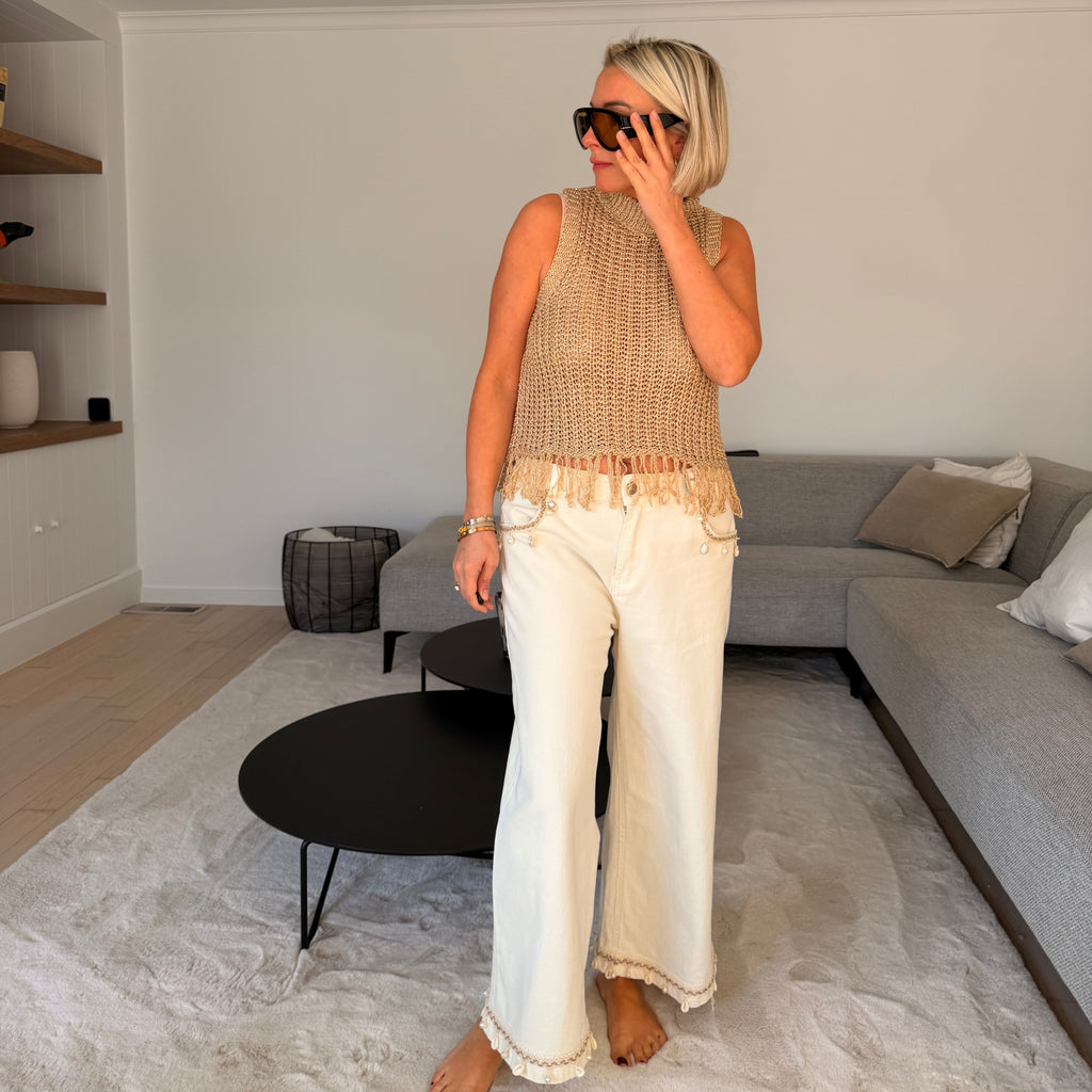 Jean écru taille haute coupe large avec détails perles. Élégant, lumineux et parfait pour un look chic et moderne.