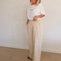 Pantalon beige fluide taille haute avec coupe large. Confortable, élégant et parfait pour un look chic et moderne.