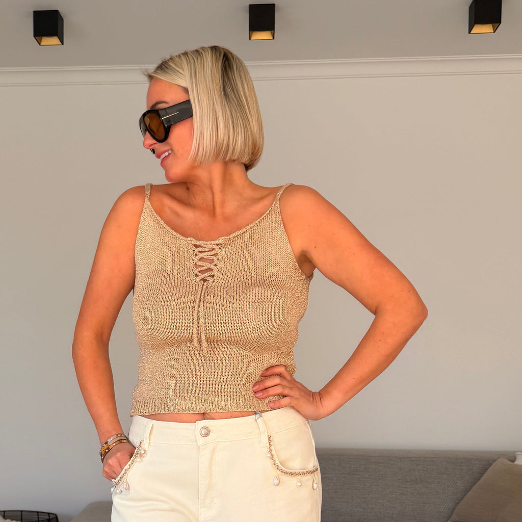 Top beige à fines bretelles avec détail lacé. Léger, féminin et parfait pour un look estival chic.